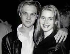 a young man and woman posing for a photo in black and white with their arms around each other