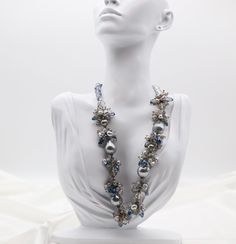 This elegant necklace features faceted blue crystals and light blue pearls, adding a touch of sophistication to any outfit. The faceted crystals reflect the light beautifully, while the pearls add a soft, feminine touch. Perfect for any occasion, this necklace will make you stand out with its stunning design. Length: 18”. Pearl: 0.61” Width. Closure: Hook and Eye. Material: Brass with Silver Plating and Rhodium Coating. Lead Free and Hypoallergenic. Elegant Blue Crystal Necklaces For Parties, Elegant Blue Crystal Necklace For Party, Elegant Blue Beaded Necklace With Faceted Beads, Blue Pearl Jewelry For Party, Blue Beaded Necklaces For Evening, Party Pearl Jewelry In Blue, Elegant Blue Pearl Necklace, Elegant Long Blue Beaded Necklace, Blue Beaded Jewelry For Evening