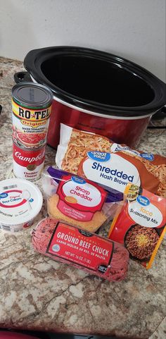 some food is sitting on top of a counter next to a crock pot and other items