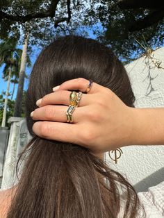 a woman's hand on top of her hair with two rings in front of her