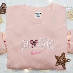 Introducing our Pink Coquette Bow x Nike Embroidered Shirt, a perfect blend of elegance and sporty style. This unique collaboration showcases a feminine pink bow beautifully embroidered on a classic Nike shirt, creating a stunning statement piece. Crafted with premium quality materials, this shirt ensures comfort and durability. Its eye-catching design effortlessly combines fashion and athletic vibes, making it a must-have addition to any girl’s wardrobe. Whether you’re hitting the g Nike Inspired, Cute Nike Outfits, Girls Nike, Cool Fathers Day Gifts, Best Mothers Day Gifts, Cute Shirt Designs, Pink Coquette, Nike Shirt, Shirt Nike