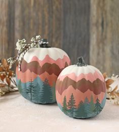 two painted pumpkins sitting on top of a table