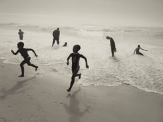 black and white photograph of children playing on the beach