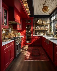 a kitchen with red cabinets and white counter tops, an area rug on the floor