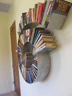 a book rack made out of books in the shape of a sunburst on a wall