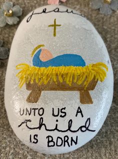 a painted rock that says unto us a child is born