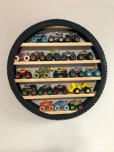 a wall mounted toy rack with cars and trucks on it's sides in a circle