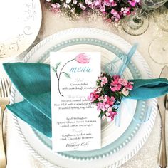 a place setting with napkins and flowers on it