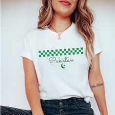 a woman wearing a white shirt with green checkerboard on the front and side