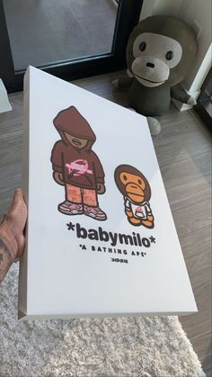 someone holding up a box with an image of a babymoo on it