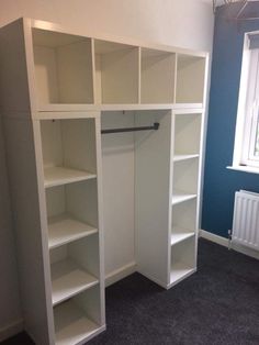 an empty white closet with shelves in the corner