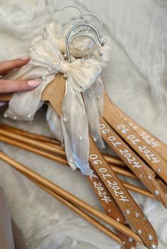 some wooden skis are sitting on a white sheet and someone is holding them with their hands