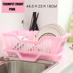 a sink with two pink plastic baskets on top of it next to a kitchen sink