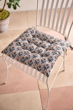 a white chair with a flowered seat cushion