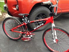 a red bike parked in front of a truck