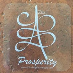 a square sticker with the word prosperity on it in white lettering, sitting on top of a brown surface