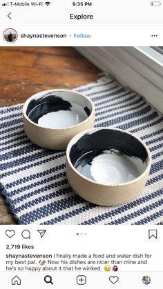 two black and white bowls sitting on top of a table