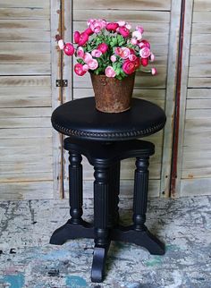 a potted plant sitting on top of a black table next to a wooden door