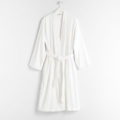 Wrap yourself in luxury. Our exclusive white bathrobe nestles you in unbelievably plush and incredibly soft organic Turkish cotton. This type of fiber turns into strong, smooth double-ply threads when spun, making the robe especially durable. The weave is looped rather than compacted so the robe dries quickly despite its dense feel.  The herringbone detail on the dobby weave adds to its elegance.  Robes are available in two sizes: small/medium and large/extra-large.   • 100% organic Turkish cott White Bathrobe, Types Of Fibres, Dobby Weave, White Dinner Plates, White Bath, Cool Glasses, Store Windows, Highball Glasses, Old Fashioned Glass