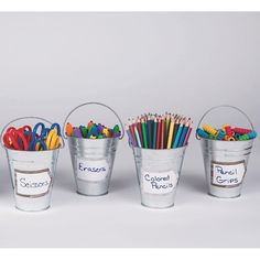 four buckets filled with colored pencils and crayons