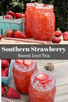 two jars filled with strawberry iced tea on top of a wooden table next to strawberries