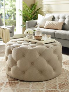 a living room with couches, chairs and a coffee table in front of a window