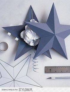 paper stars, ruler, and scissors on a white table with some other crafting supplies