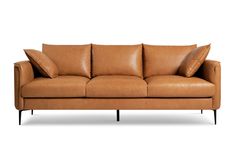 a tan leather couch with two pillows on it's back and one arm extended