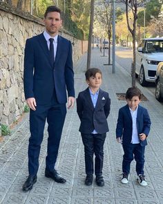 a man in a suit walking with two children