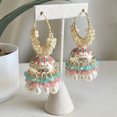 "Take your style to new heights with these playful and fun chandbali meenakari jhumka hoop earrings. These earrings feature a chandbali design with colorful meenakari enamel that will make you the center of attention. The delicate hoops sway and dance with your movements, adding a playful touch to any outfit. Made to impress, these jhumkas are the perfect way to accessorize traditional outfits. Their versatile design ensures easy pairing with both Indian and Western ensembles. Let your inner beauty shine through and make these meenakari jhumkas your accessory for making a stylish statement! Length 3\" | Width 1.5\" Items are carefully packed and ready for gifting. All pictures are taken in natural light please allow for slight variations in color due to camera settings. Jewelry Care ✨Prote Luxury Latkan Earrings For Celebrations, Luxury Festive Chandelier Earrings With Latkans, Cheap Dangle Chandelier Earrings With Latkans, Jhumka Designs Gold Indian, Meenakari Hoop Earrings For Diwali Party, Indian Jhumka, White Dangle Hoop Earrings For Festivals, Hoop Earrings For Celebrations And Festivals, Festival Hoop Earrings For Celebration