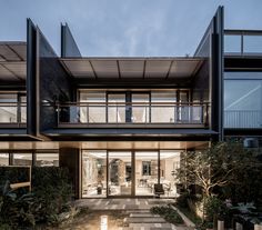 a modern house with large windows and lots of plants