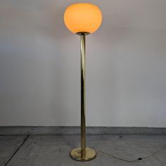 a floor lamp with a yellow light on it