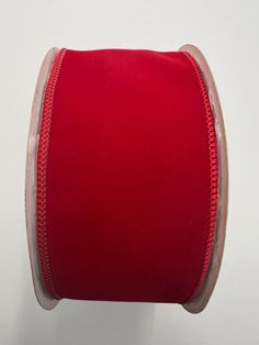 a roll of red ribbon on a white wall