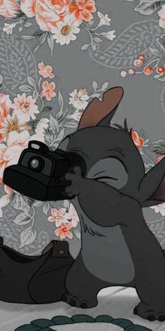 a cartoon character holding a camera in front of flowers on a floral wallpaper background