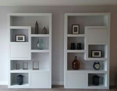 two white bookshelves with pictures and vases on them