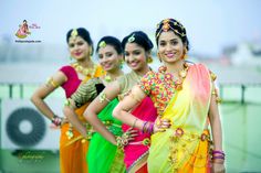 three beautiful women in colorful saris posing for the camera with their hands on their hips