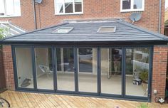 a backyard with a wooden deck and glass doors