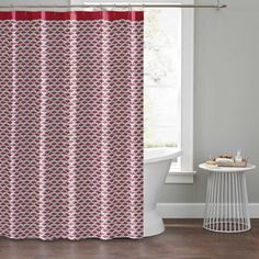 a bathroom with a bathtub, sink and shower curtain that has red circles on it