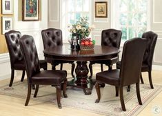 a dining room table with brown chairs around it