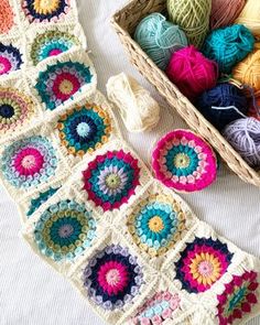 there are crocheted grannys and balls of yarn on the bed