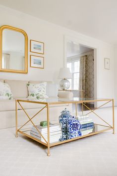 a living room filled with furniture and a mirror on top of the coffee table in front of it