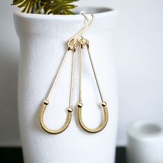 Upgrade your style with these stunning Harley Gold Coil Hoops. Long hoops crafted from 14k gold filled wire, these earrings feature a unique twist in the form of golden coils, for a look that's sure to turn heads. Wear them day or night for a dash of elegant, eye-catching flair! Approximately 2.25” long Made with 14k Gold Filled Polished to a high shine Handmade in Montana Sent in a ribboned gift box with polishing cloth Plastic Pouch, Gold Filled Hoops, Modern Earrings, Wire Earrings, Coils, Ear Wire, Long Earrings, Handmade Earrings, Montana