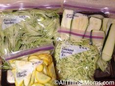 there are many different types of vegetables in the plastic bags on the counter top, including cucumbers and zucchini