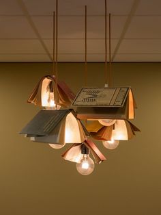 three lamps hanging from the ceiling with books on them