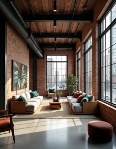 a living room filled with lots of furniture next to large windows on top of a brick wall