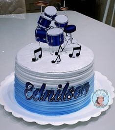 a birthday cake with drums and music notes on the top is sitting on a table