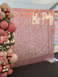 a pink and gold party decoration with balloons on the top, flowers in the bottom