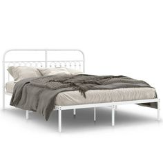 a white metal bed frame with two pillows on it