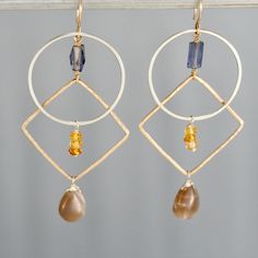 "These modern earrings feature two handmade geometric shapes. They are made from 14k yellow gold filled and sterling silver. They are given flat and hammered texture and a shiny finish. The ear wires are 14k gold filled. This pair has denim blue iolite along with yellow citrine and peach moonstone drops. Measures 2 3/4\" long including the ear wires." Modern Gold Earrings With Gemstone Accents, Hammered Gold Ring, Geometric Hoop Earrings, Hammered Gold, Yellow Citrine, Peach Moonstone, Sterling Silver Flowers, Modern Earrings, Simple Jewelry