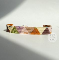 a bracelet made out of beads with different colors and shapes on the inside of it